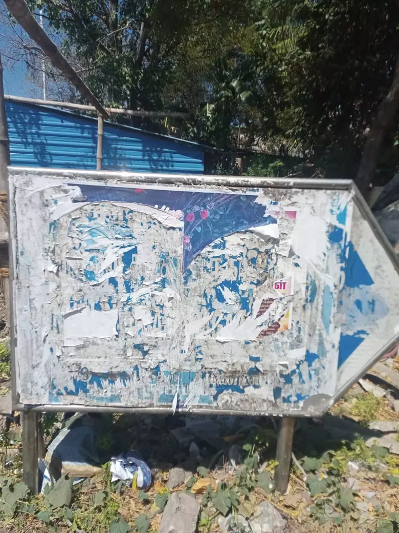 சுவரொட்டிகளால் நிரம்பிய பெயர் பலகை