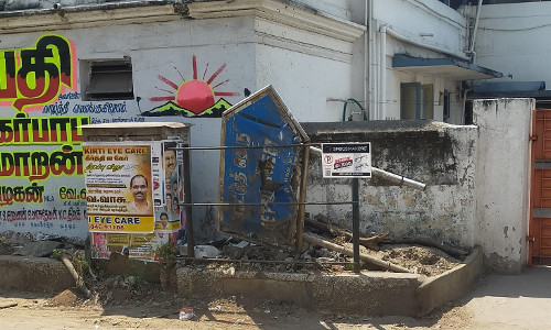 குப்பைகளுடன் இருக்கும் பெயர் பலகை குப்பைகளுடன் இருக்கும் பெயர் பலகை