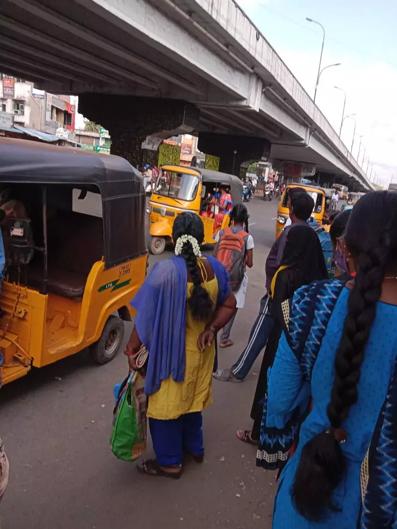 பஸ்சுக்காக காத்திருக்கும் மக்கள்