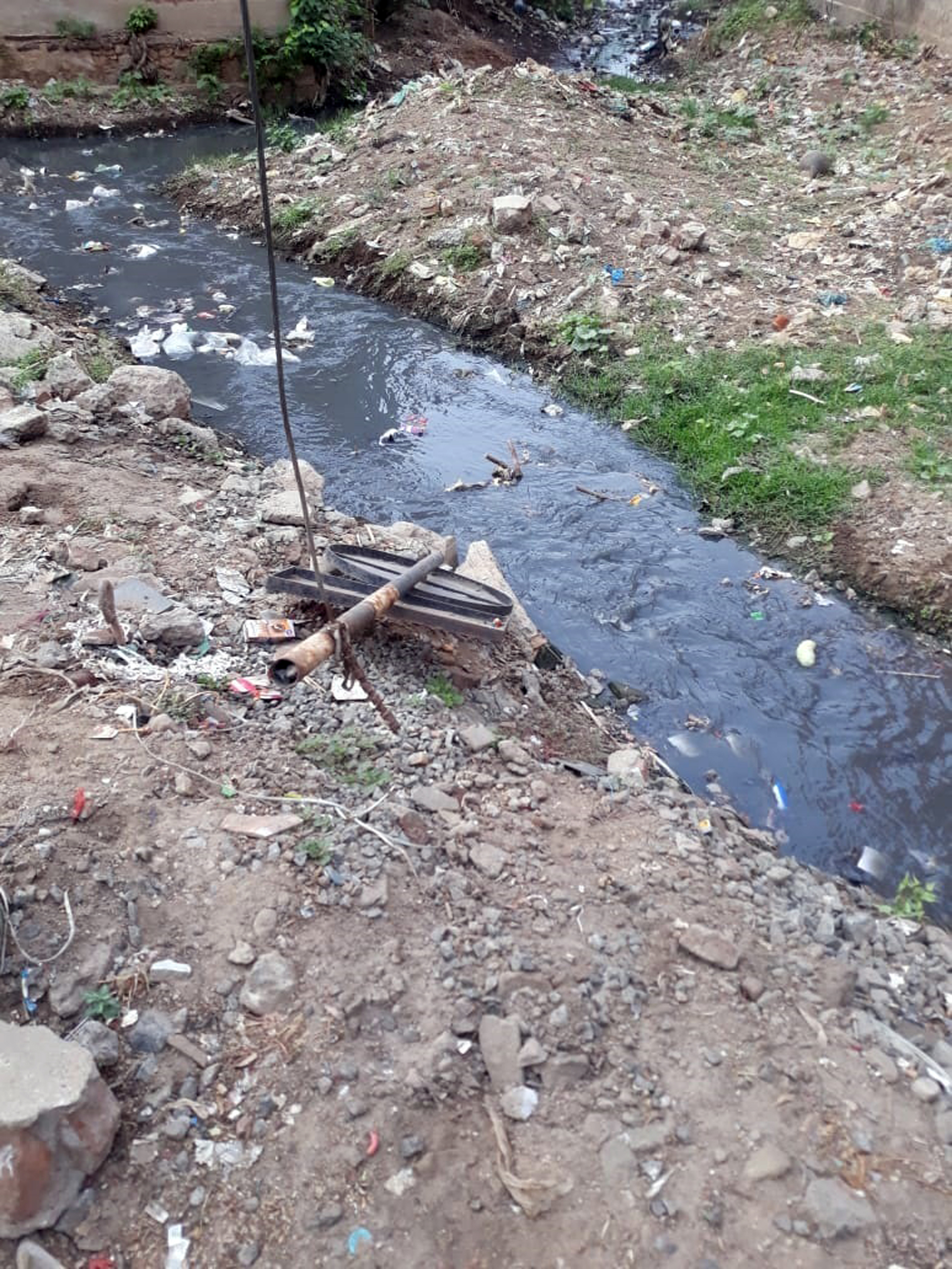 ஓடையில் கிடக்கும் எச்சரிக்கை பலகை