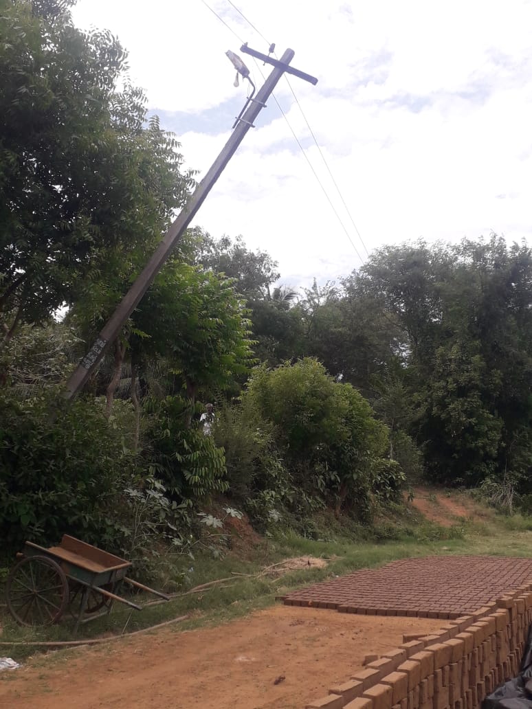 சாய்ந்த நிலையில் மின்கம்பம்