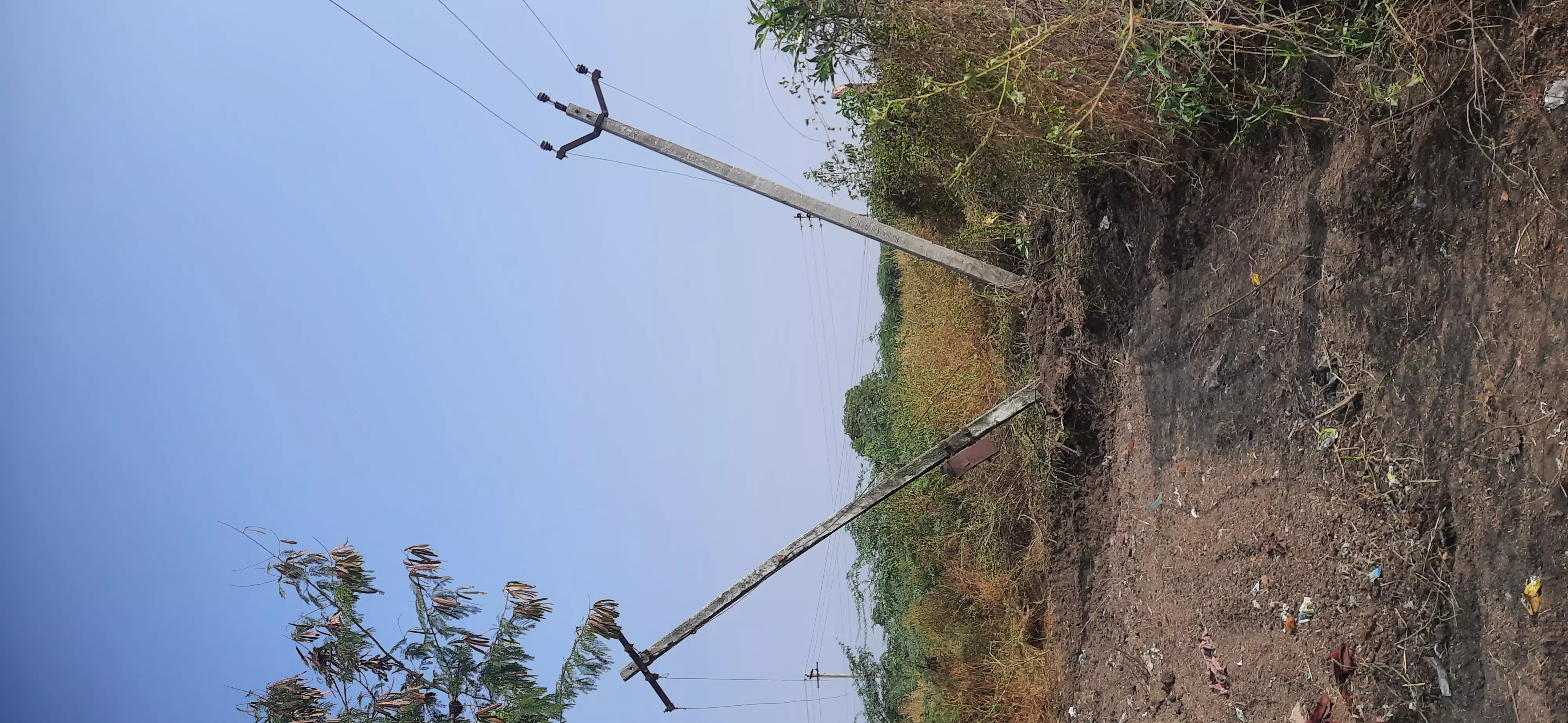 சாய்ந்த நிலையில் மின்கம்பம் சாய்ந்த நிலையில் மின்கம்பம்