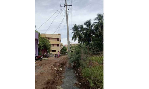 கால்வாய் நடுவே மின்கம்பம்