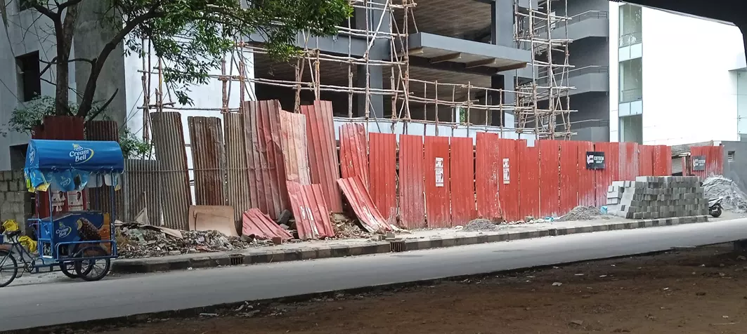 நடைபாதையில் குவிந்து கிடக்கும் கட்டுமான பொருட்கள்