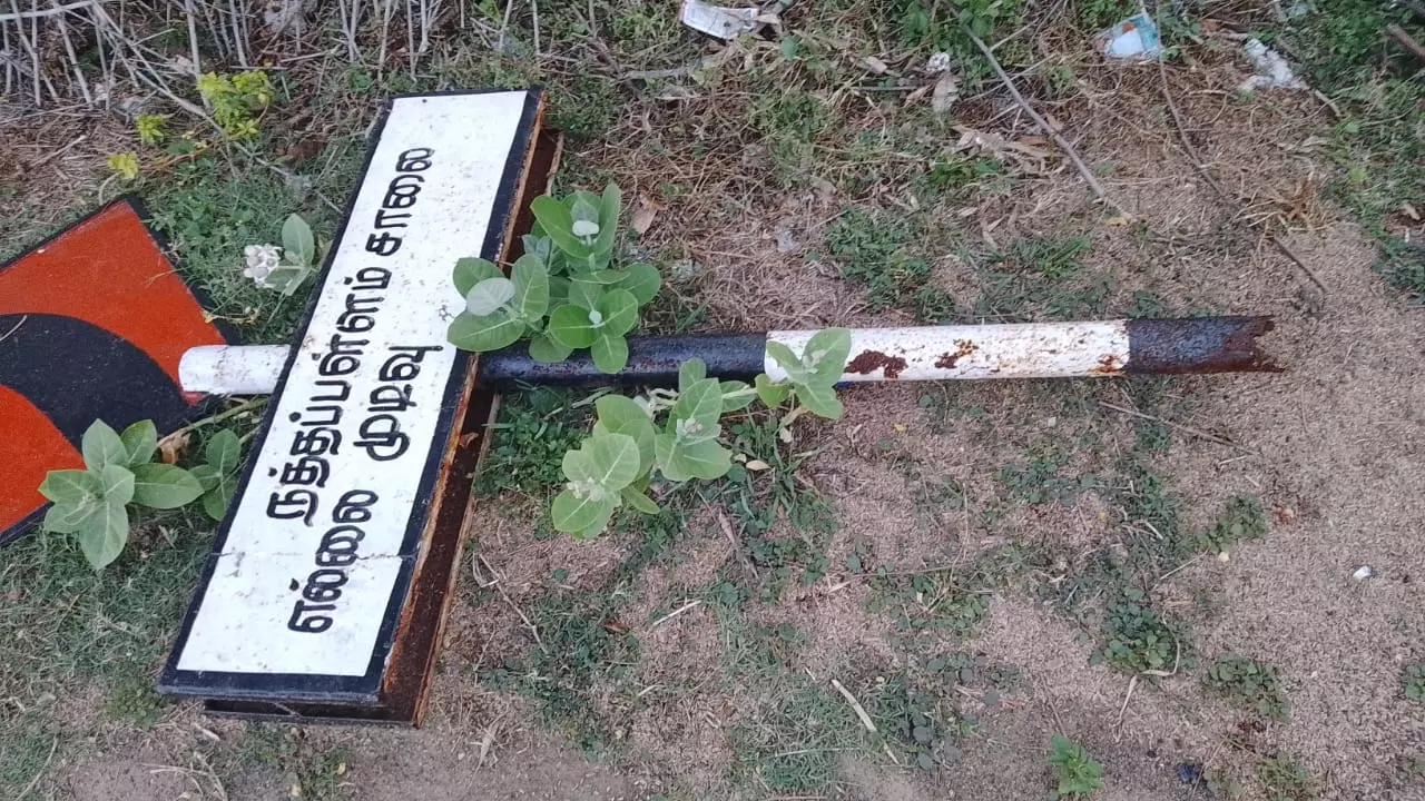 உடைந்து கிடக்கும் எல்லைமுடிவு அறிவிப்பு பலகை உடைந்து கிடக்கும் எல்லைமுடிவு அறிவிப்பு பலகை