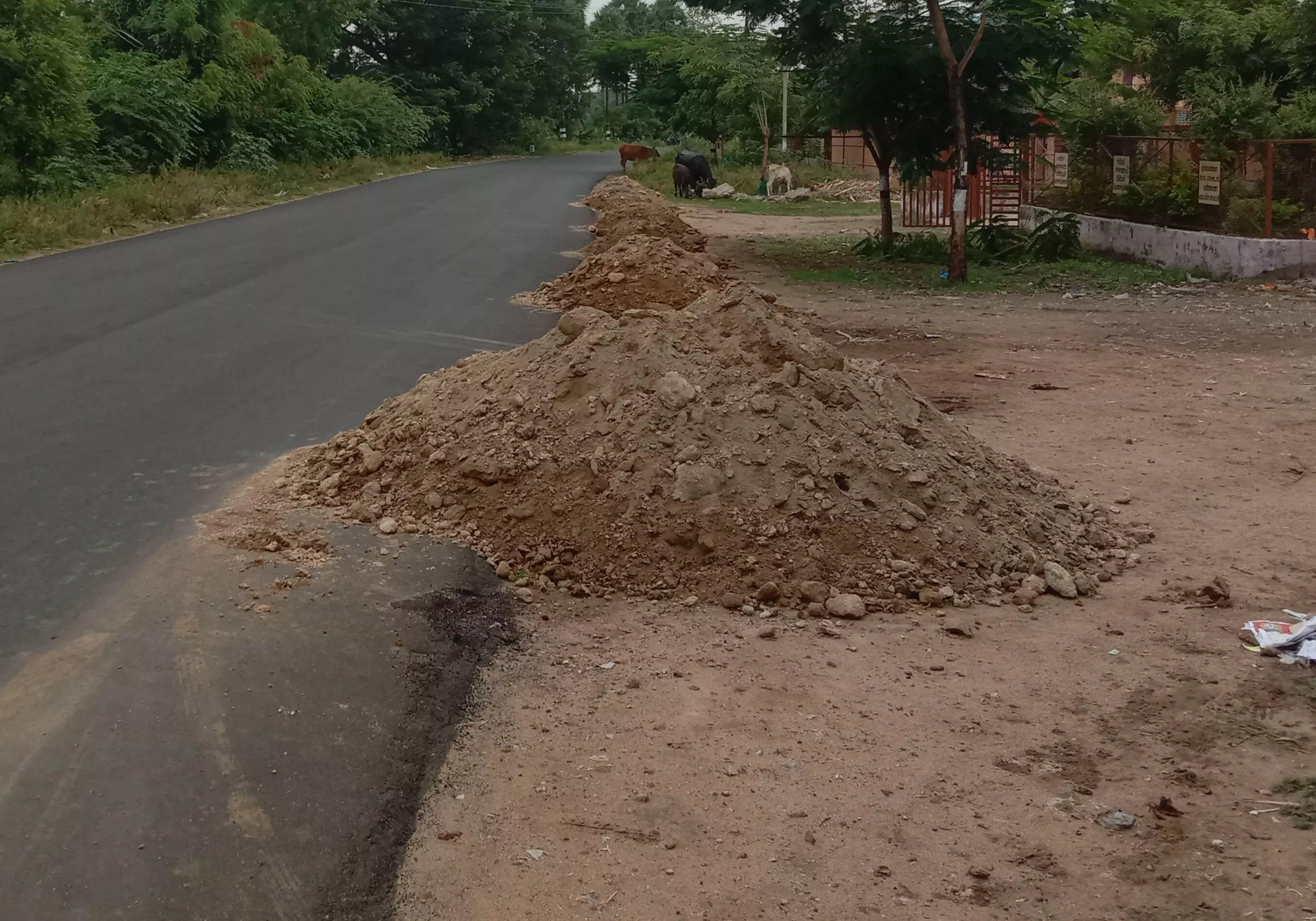 சாலையோரம் கொட்டப்பட்டுள்ள மண்