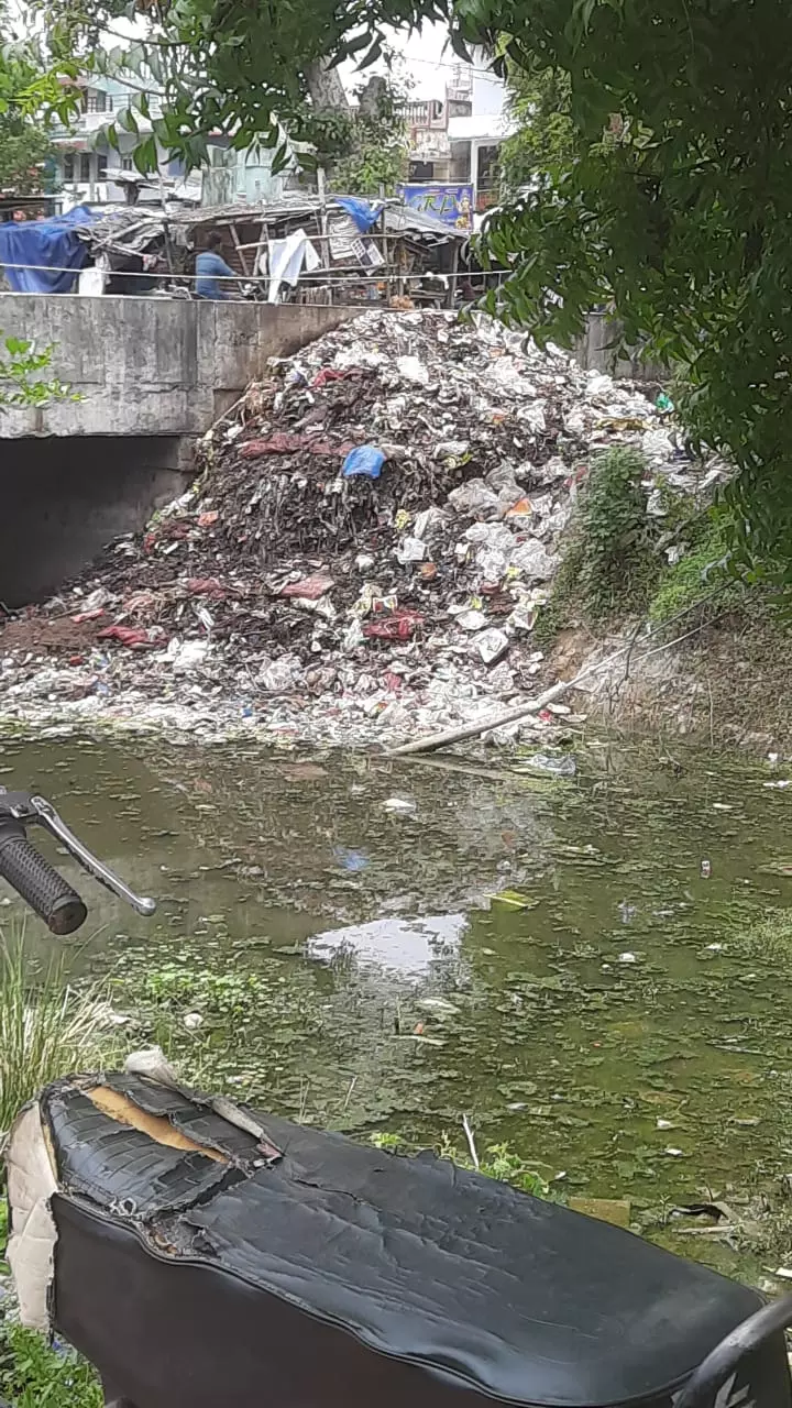 வாய்க்காலில் கொட்டப்படும் குப்பைகள்