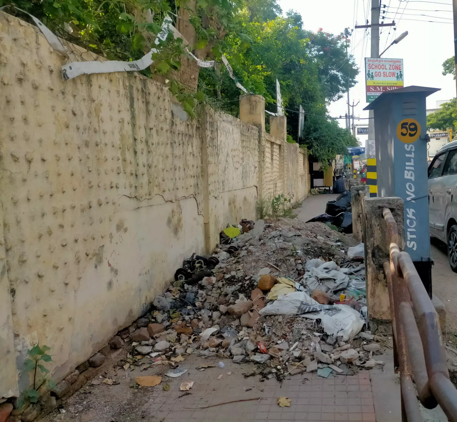 நடைபாதையில் கட்டிட கழிவுகள்