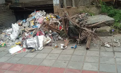 நடைபாதையில் கிடக்கும் குப்பை கழிவுகள்