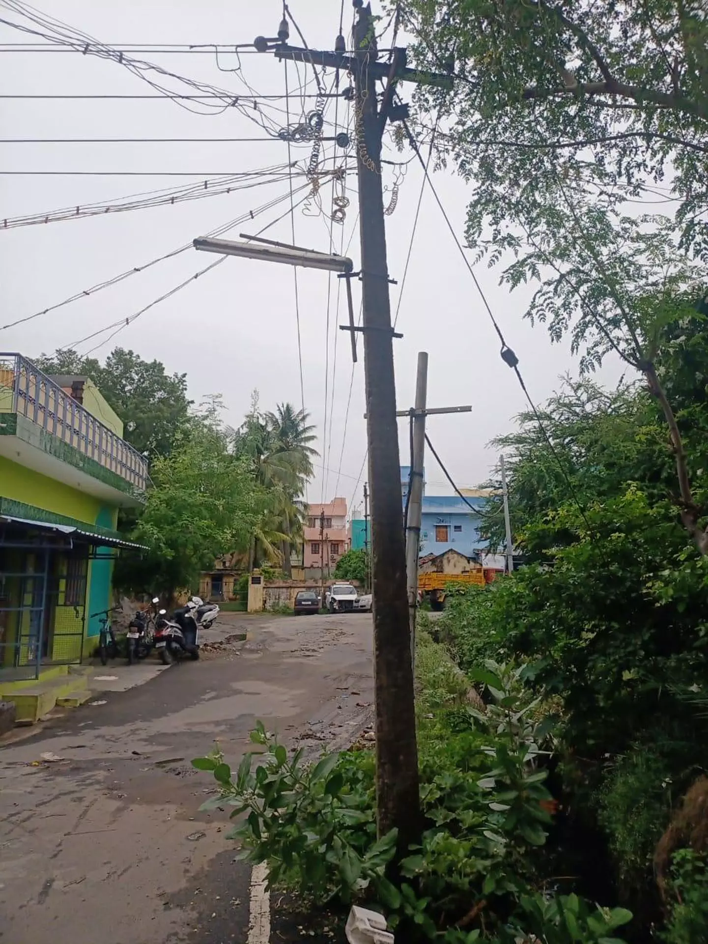 சாய்ந்த நிலையில் மின்கம்பம்