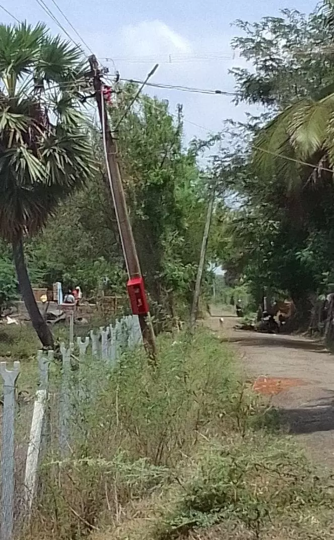 சாய்ந்த நிலையில் மின் கம்பம்