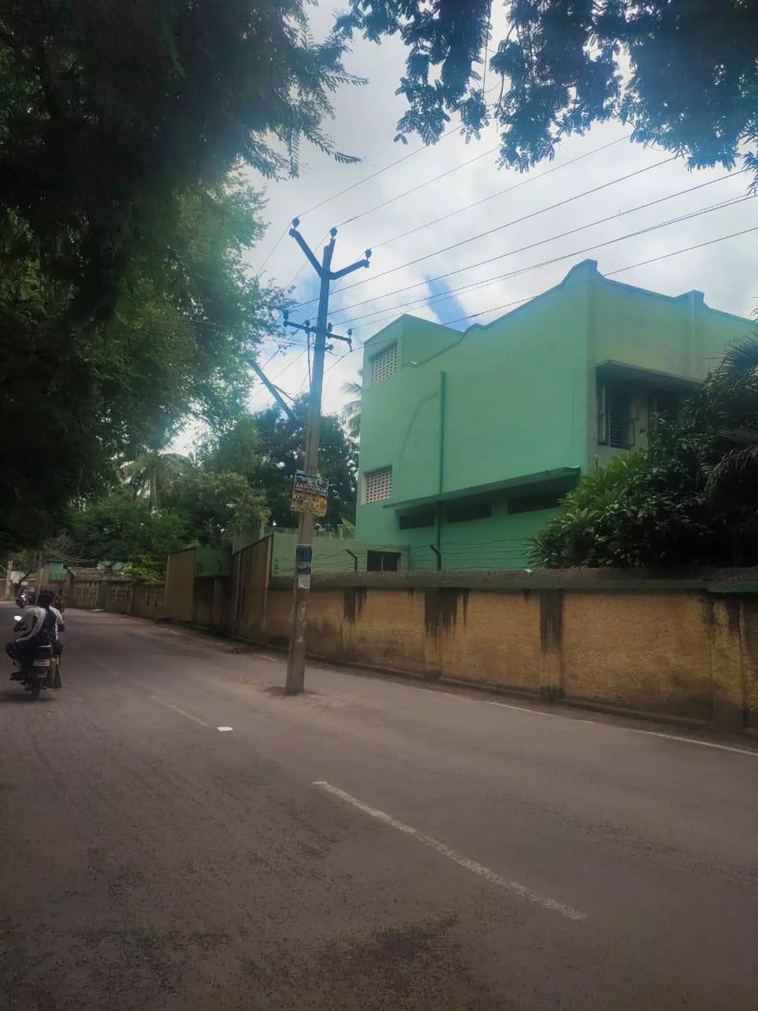 சாலையின் நடுவே மின்கம்பம்