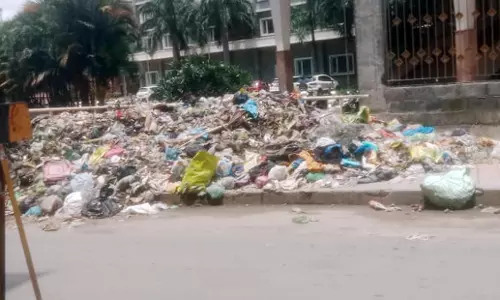 நடைபாதையில் குவிந்து கிடக்கும் குப்பை