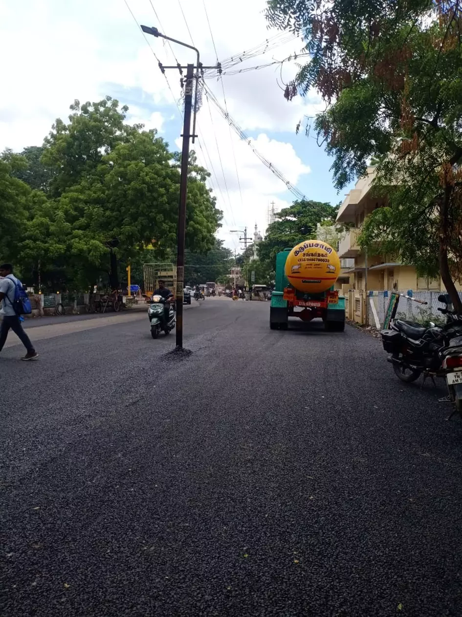 சாலையின் நடுவே மின்கம்பம்