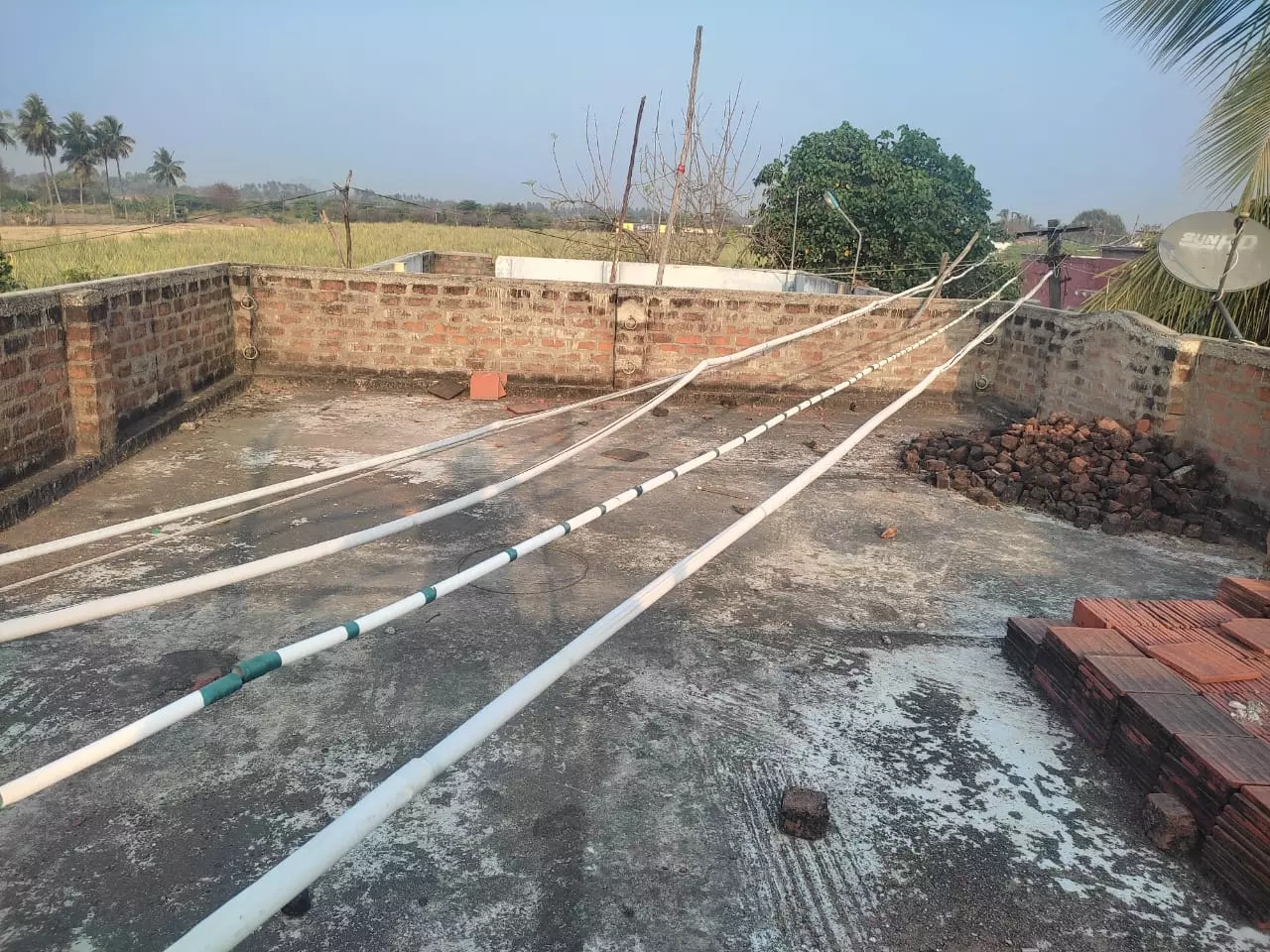 வீடுகளுக்கு மேல் தாழ்வாக செல்லும் மின்கம்பிகள்