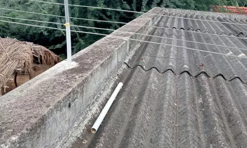 வீட்டை உரசியபடி செல்லும் மின்கம்பிகள்