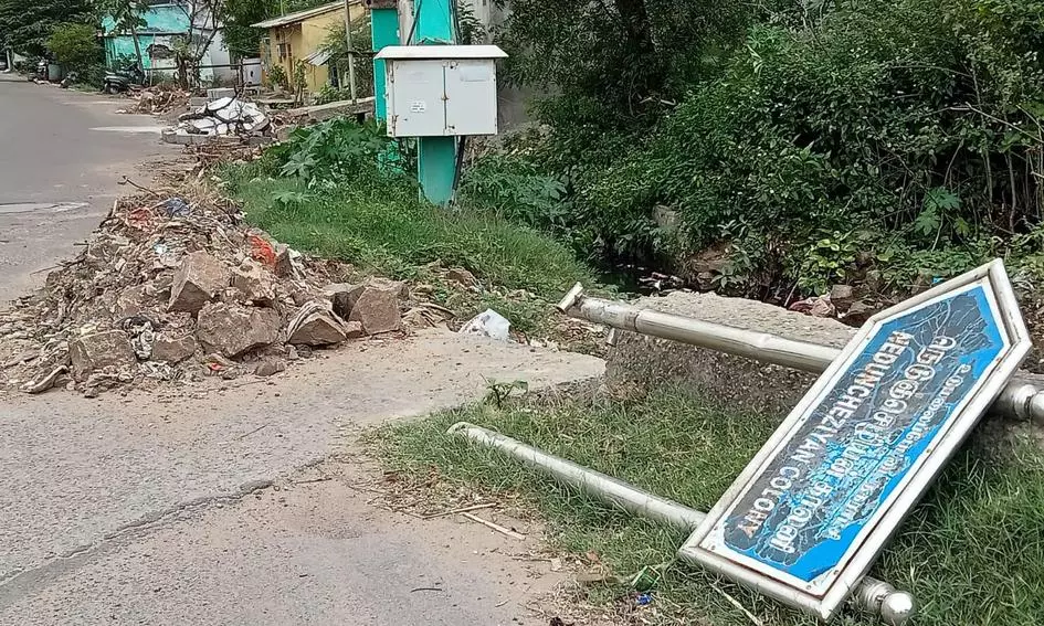 சாய்ந்து கிடக்கும் தகவல்பலகை சாய்ந்து கிடக்கும் தகவல்பலகை