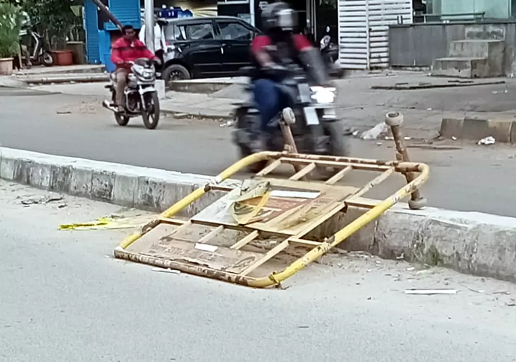 நடுரோட்டில் கிடக்கும் இரும்பு தடுப்பு பலகை