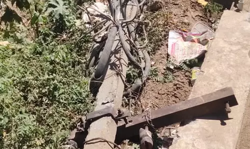 தரையில் விழுந்து கிடக்கும் மின்கம்பம்