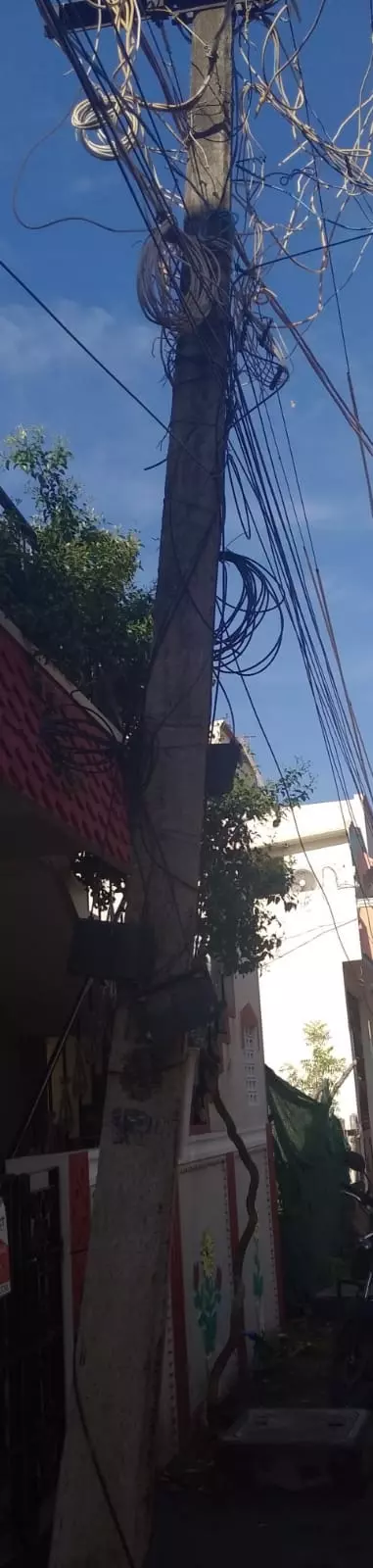 சாய்ந்த நிலையில் மின்கம்பம்