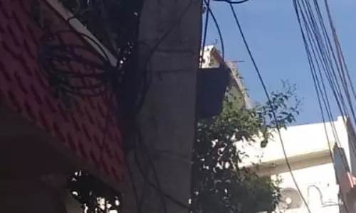 சாய்ந்த நிலையில் மின்கம்பம்