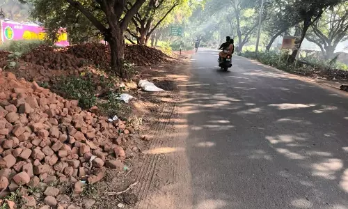 சாலையோரத்தில் குவியும் செங்கல் கற்கள்