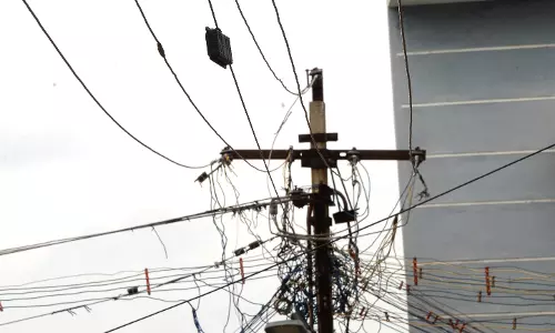 மின்கம்பிகளுக்கு இடையே இன்டர்நெட் கேபிள் மின்கம்பிகளுக்கு இடையே இன்டர்நெட் கேபிள்