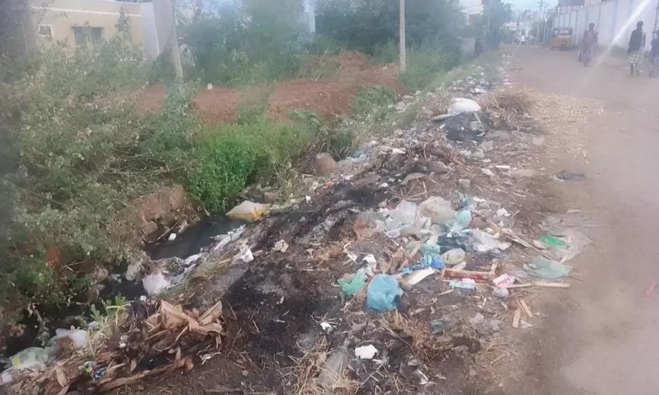 சாக்கடை கால்வாயில் குப்பைகள்