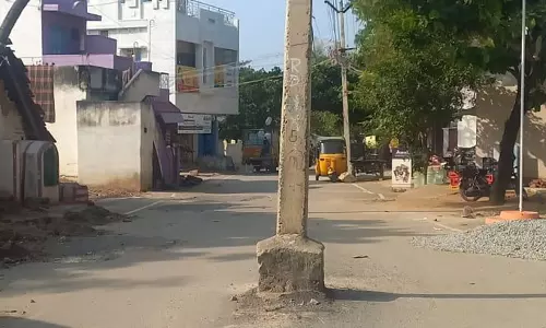 சாலையின் நடுவே மின்கம்பம்