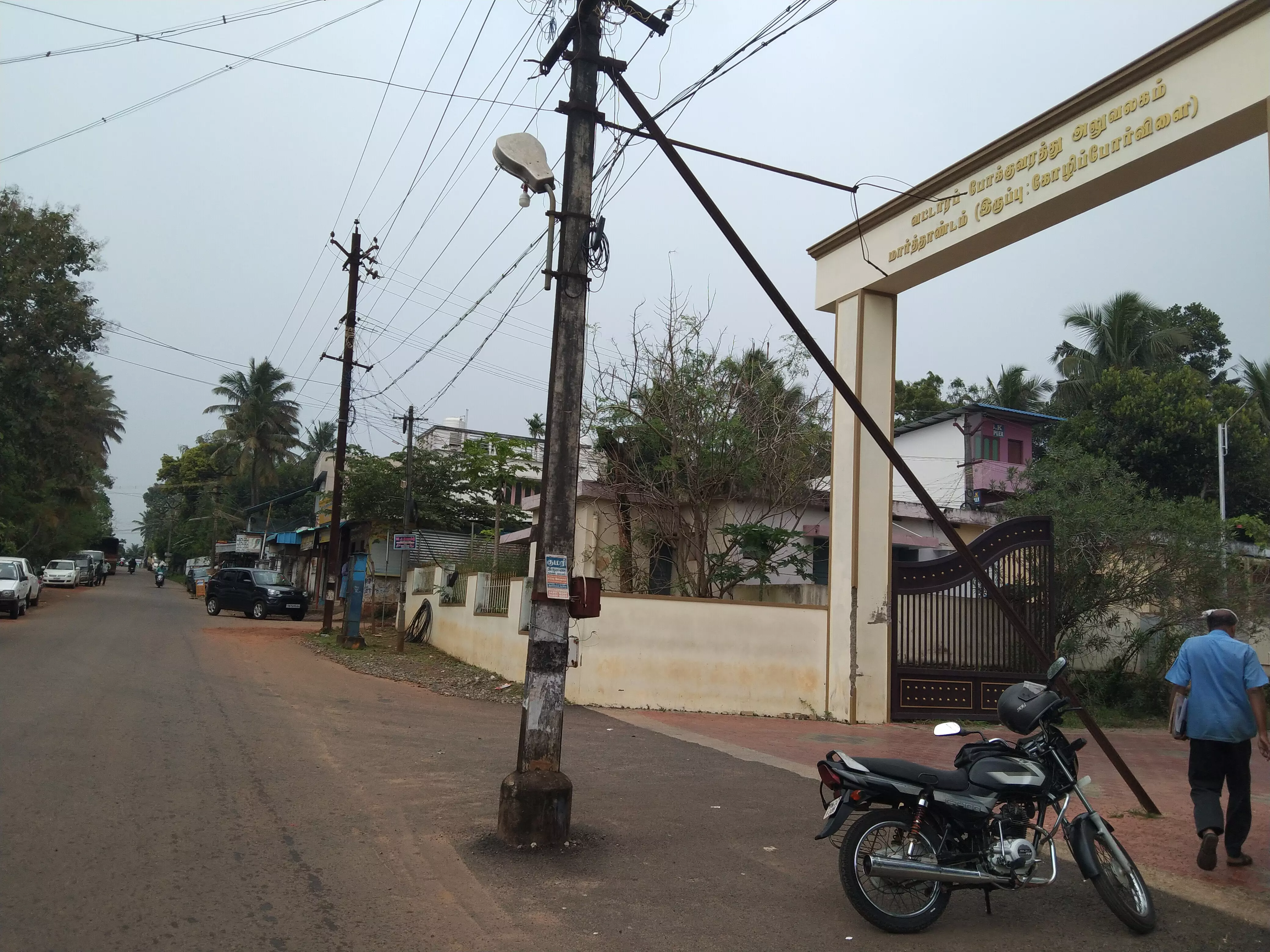 சாலையில் நிற்கும் மின்கம்பம்