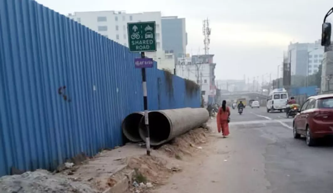 நடைபாதையில் கிடக்கும் ராட்சத குழாய்கள்