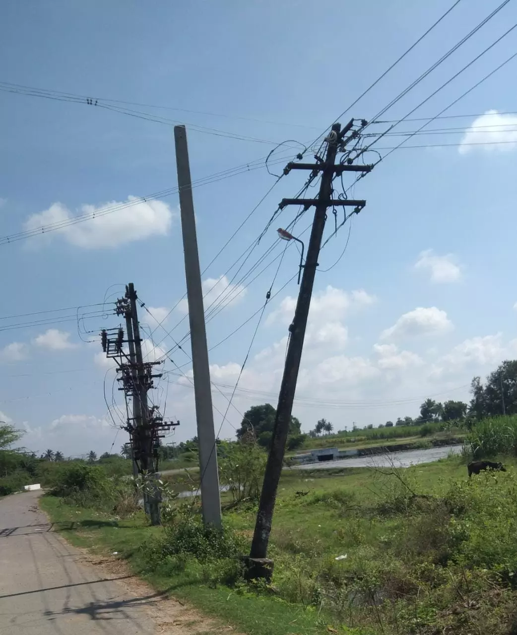 சாய்ந்த நிலையில் மின்கம்பம்