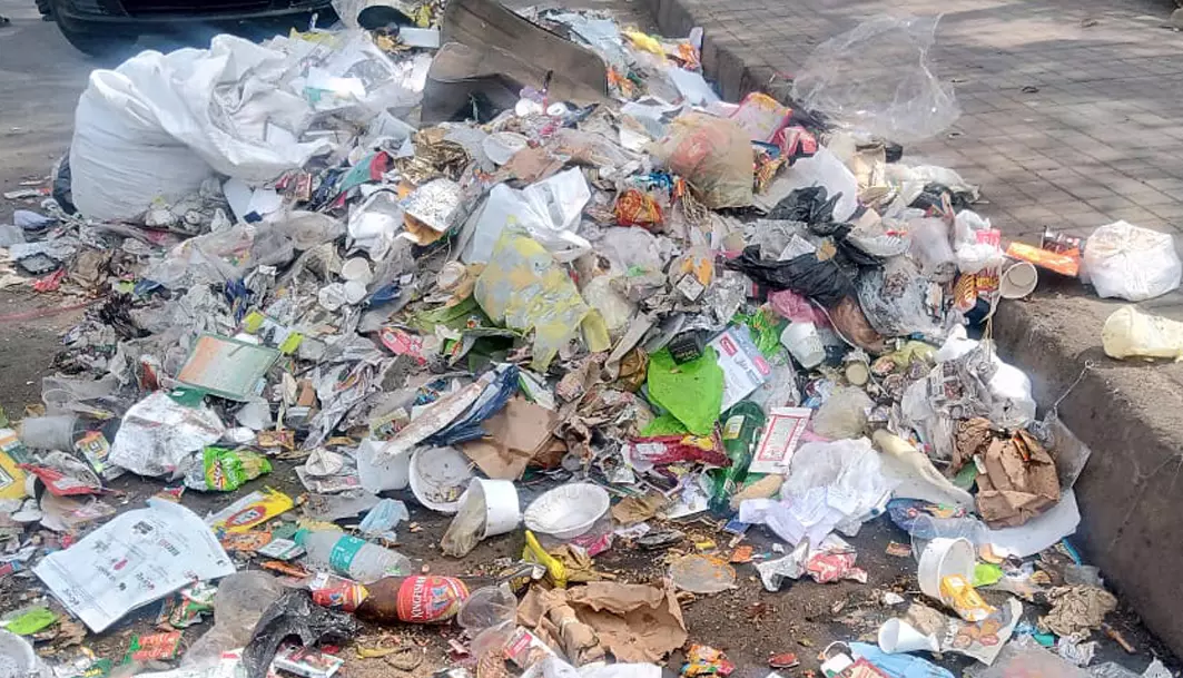 சாலையோரம் குவிந்து கிடக்கும் குப்பை