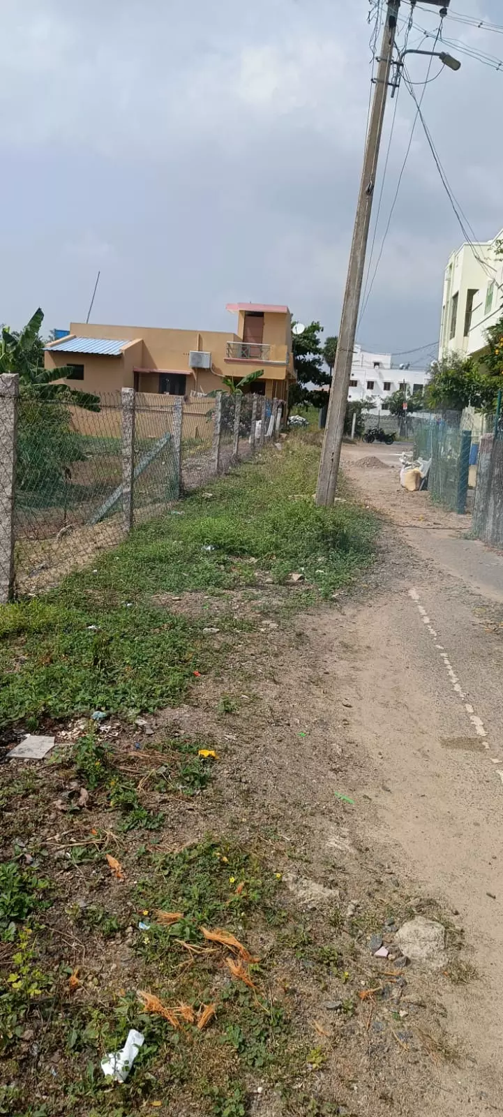 சாலையின் நடுவே உள்ள மின்கம்பம்