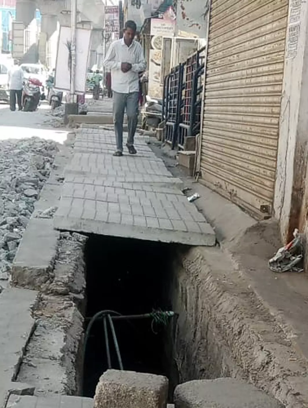 உடைந்து கிடக்கும் நடைபாதை சிமெண்டு சிலாப்புகள்