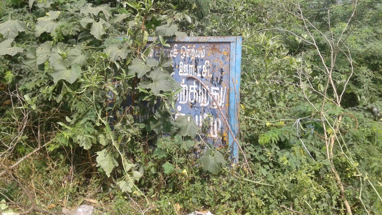 புதர் மண்டி கிடக்கும் பெயர் பலகை