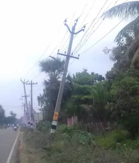 சாய்ந்த நிலையில் மின்கம்பம்