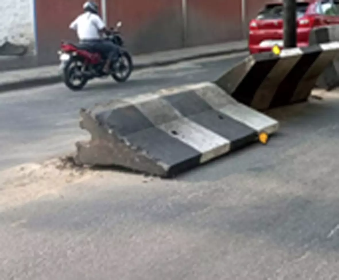 சாய்ந்து கிடக்கும் சாலை தடுப்பு