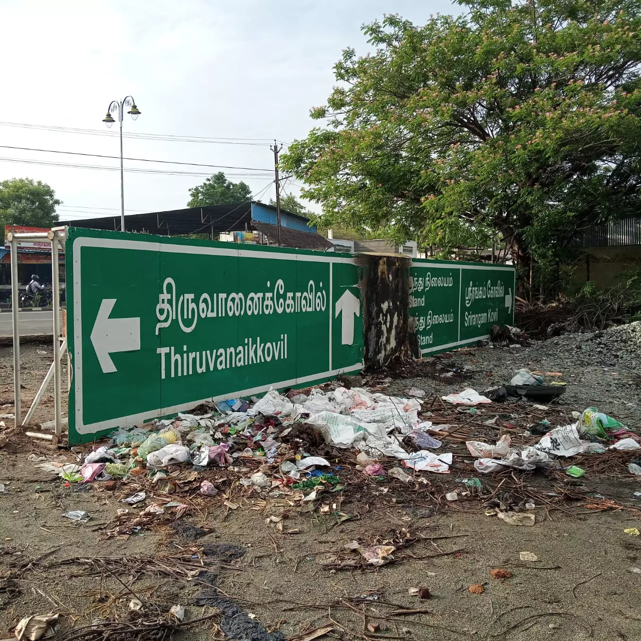 சாலையோரம் கிடக்கும் ஊர் வழிகாட்டி பெயர் பலகை