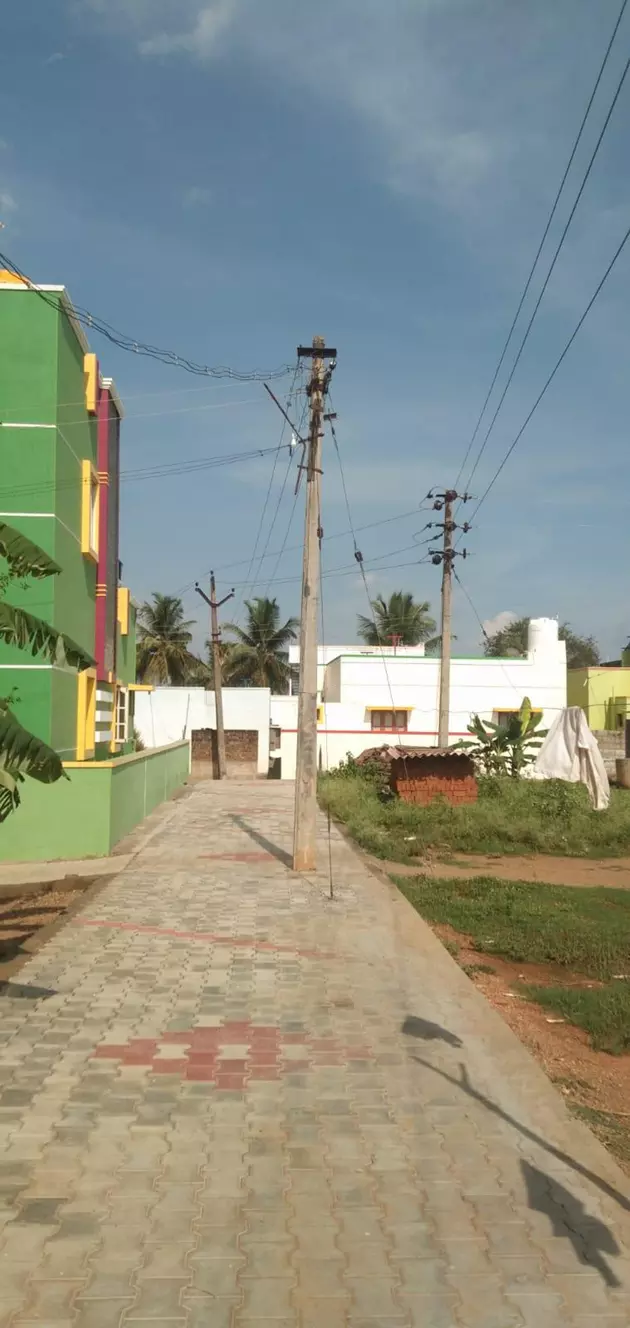 சாலையின் நடுவே மின்கம்பம்