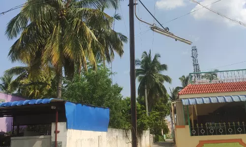 சாலையின் நடுவே மின்கம்பம்