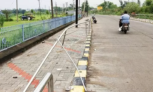 உடைந்து கிடக்கும் நடைபாதை தடுப்பு கம்பிகள்