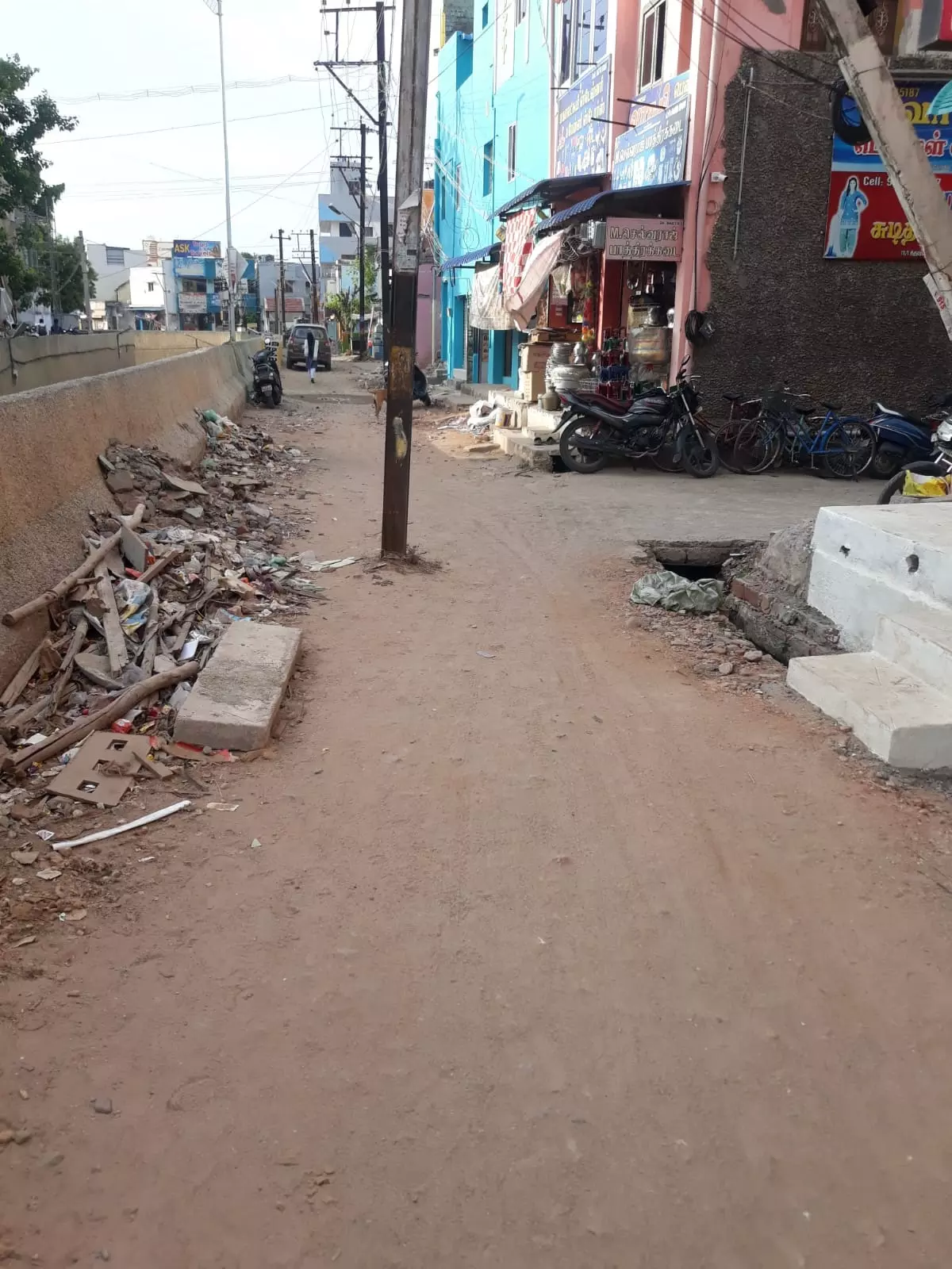 சாலையின் நடுவில் மின்கம்பம்