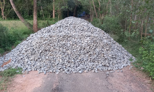 சாலையின் நடுவே கொட்டப்பட்டுள்ள ஜல்லிக்கற்கள்