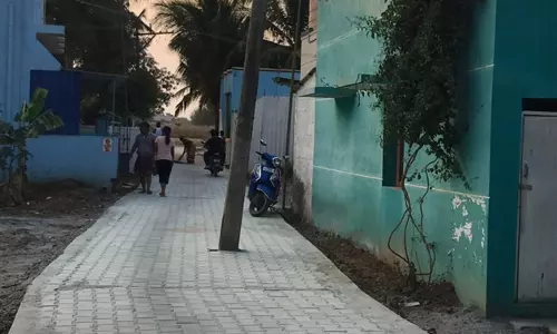 சாலையின் நடுவே மின்கம்பம்