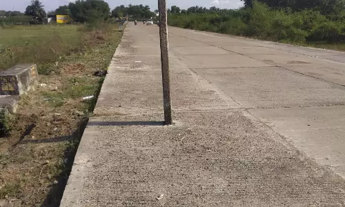 சாலையின் நடுவில் மின்கம்பம்