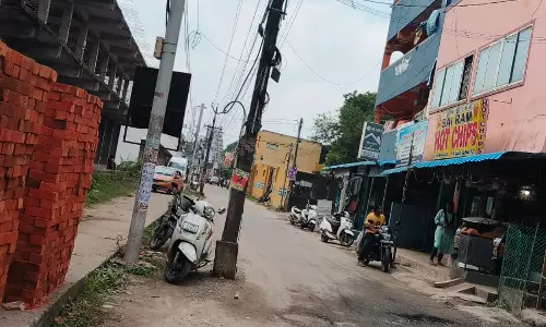 சாலையின் நடுவில் மின்கம்பம்