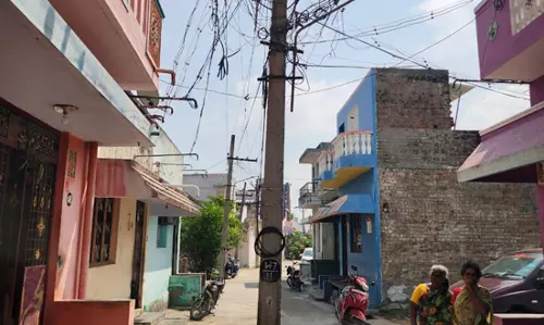 சாலையின் நடுவே மின் கம்பம்