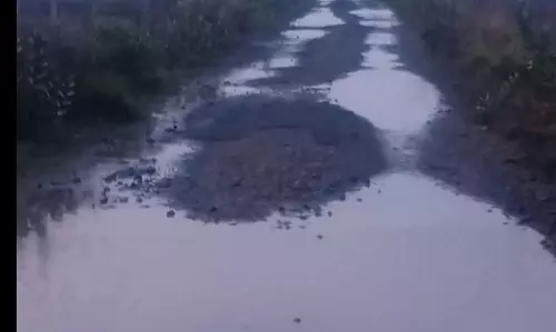குண்டும், குழியுமான தார் சாலை