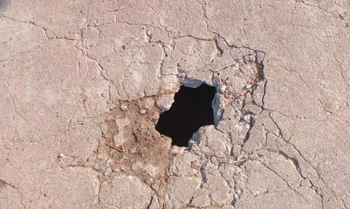 சிமெண்டு சாலையில் பள்ளம்